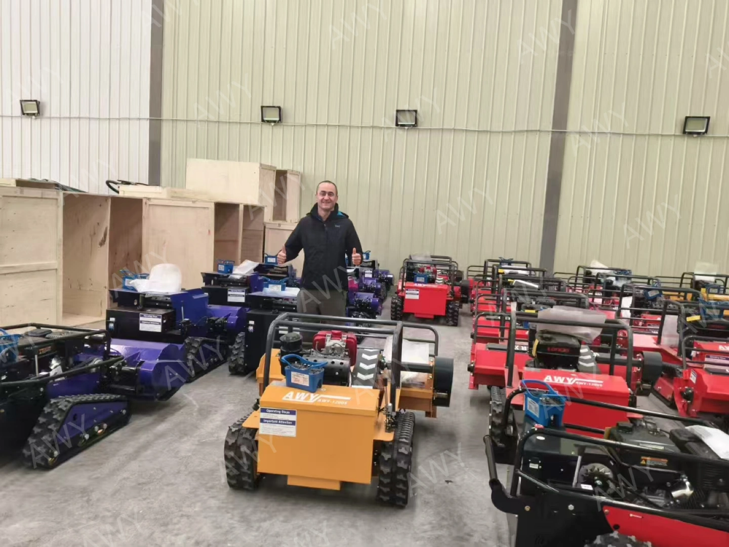 Customer posing with delivered mower batch in factory